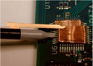 Ground blade connecting to a copper foil ground plane soldered to the ground pins on an IC