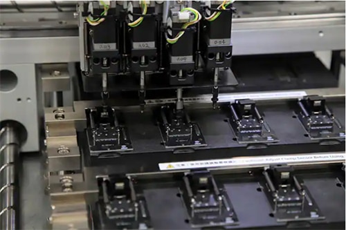 DigiKey's automated programming machine placing a blank oscillator in one of the programming sockets