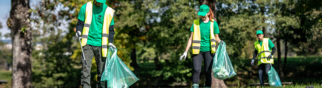 Team of employees in green shirts and yellow vests on pick up duty
